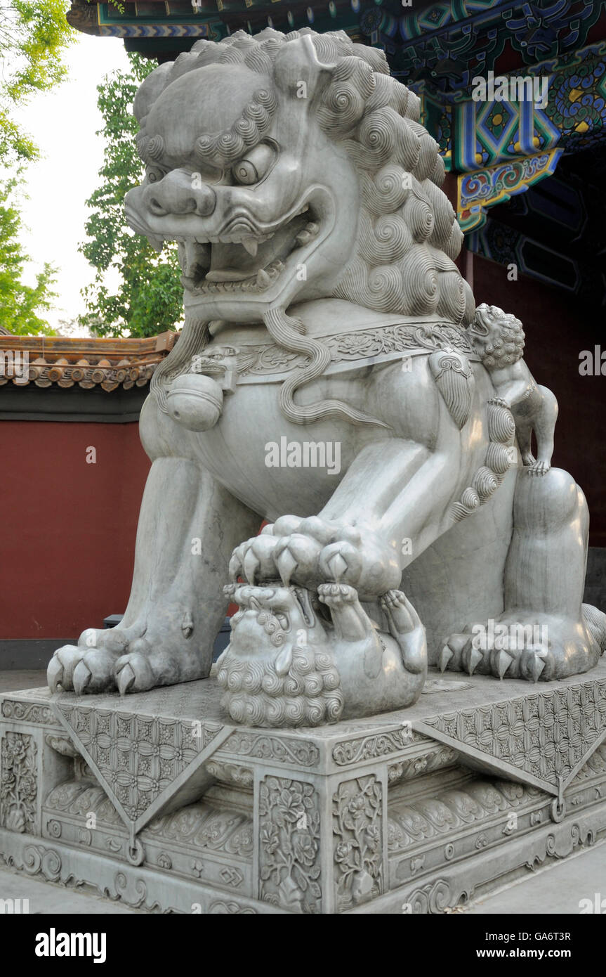 Une statue de lion chinois pierre debout sur un plus petit, à l'entrée