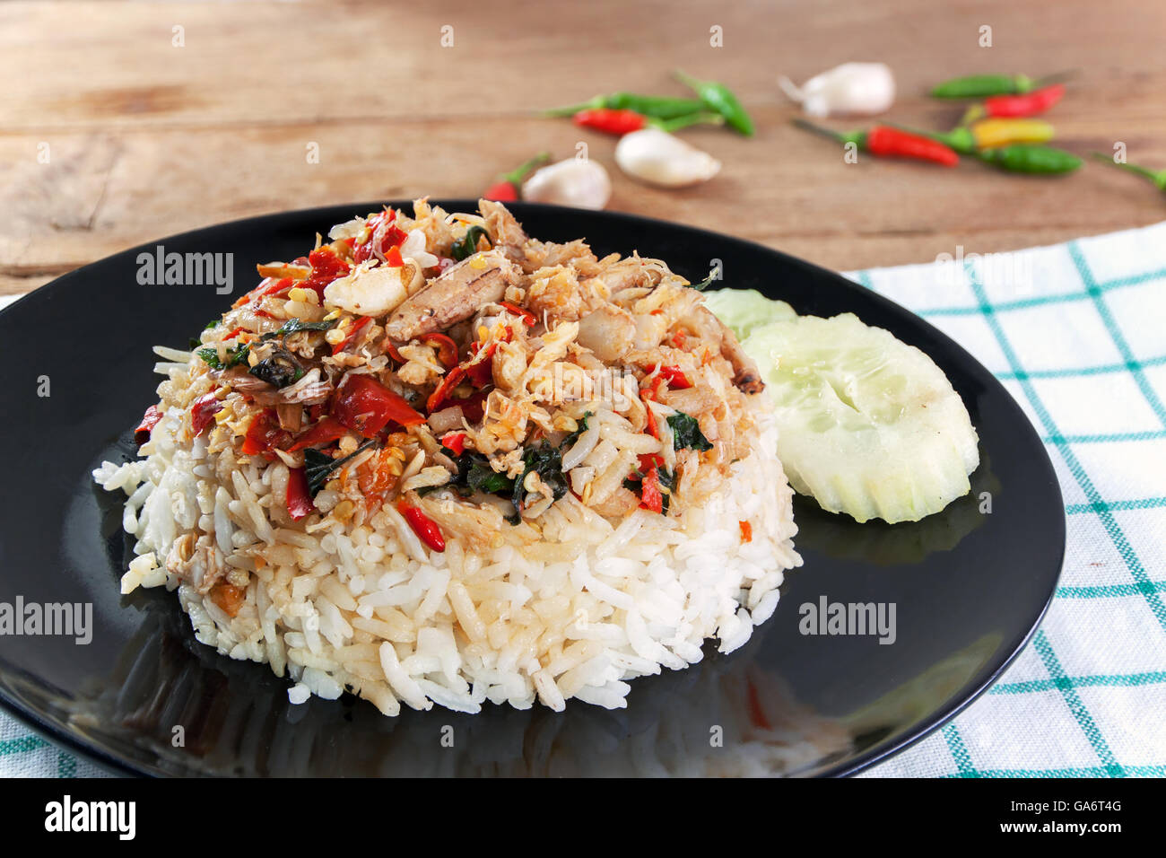 Garni de riz sauté de viande de crabe et le basilic dans un plat noir sur blanc bois Banque D'Images