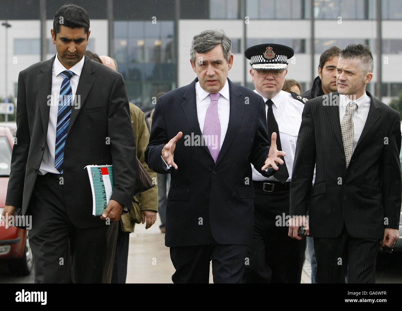 Le Premier ministre Gordon Brown visite le quartier général de la police de Gloucestershire à Quedgeley avec le chef de police de Gloucestershire, Tim Brain (au centre à droite), et le député de Gloucester, Parmjit Dhanda (à gauche), pour voir comment la réponse d'urgence aux inondations est coordonnée. Banque D'Images