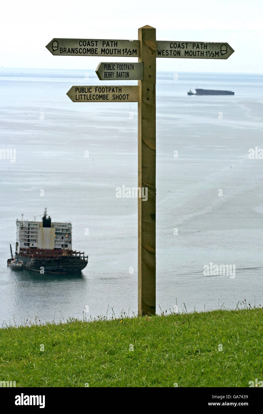 Un remorqueur de garde-côtes commence à remorquer la section de l'arc de la Napoli loin de la poupe restante, à la plage de Branscombe près de Sidmouth, Devon. Banque D'Images
