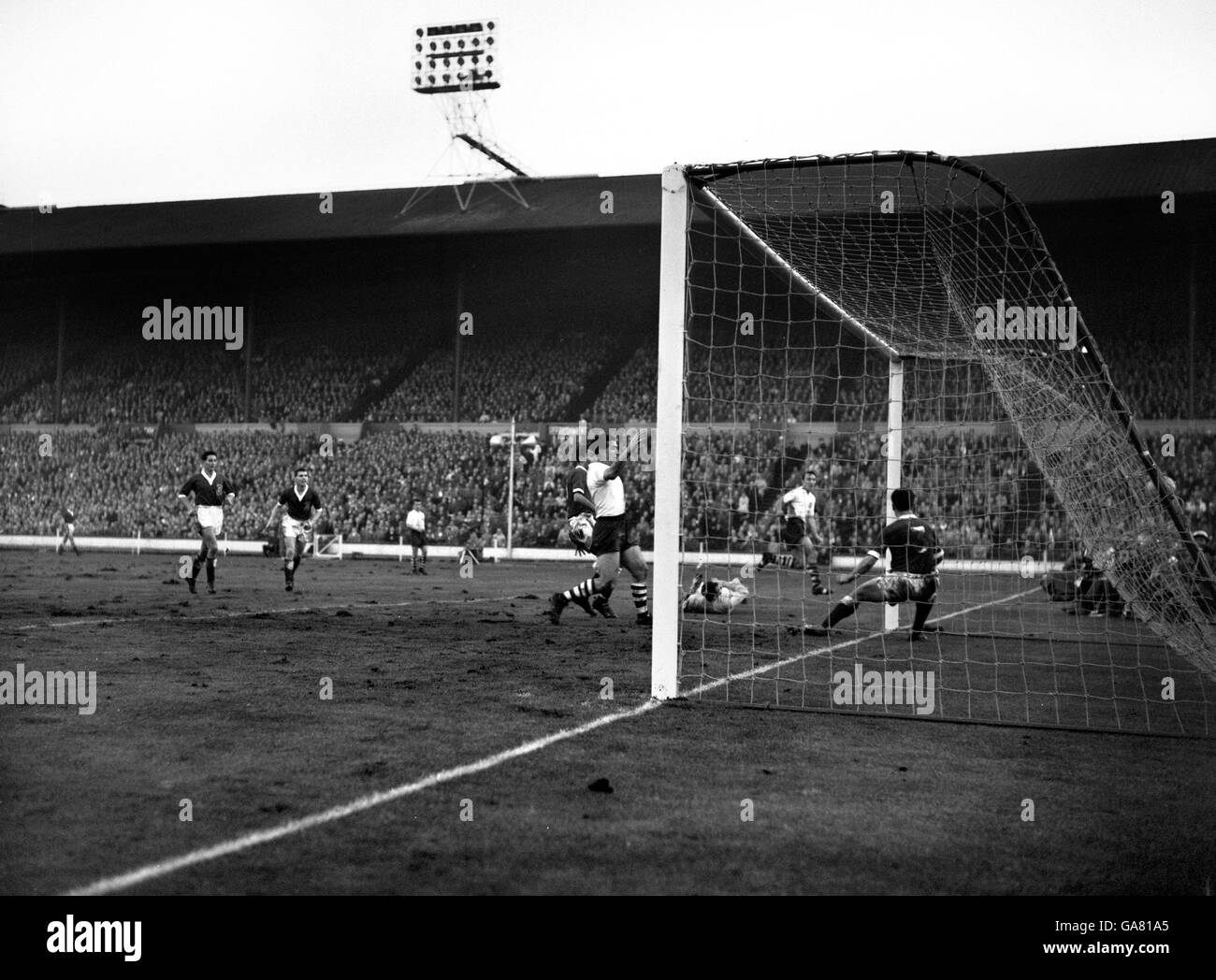 Le cinquième but de l'Angleterre, marqué par Jimmy Greaves (deuxième à droite). Les autres joueurs vus sont: Mel Nurse (pays de Galles), Bobby Smith (Angleterre), Jack Kelsey (gardien de but du pays de Galles) et Graham Williams (pays de Galles) dans le filet. Banque D'Images