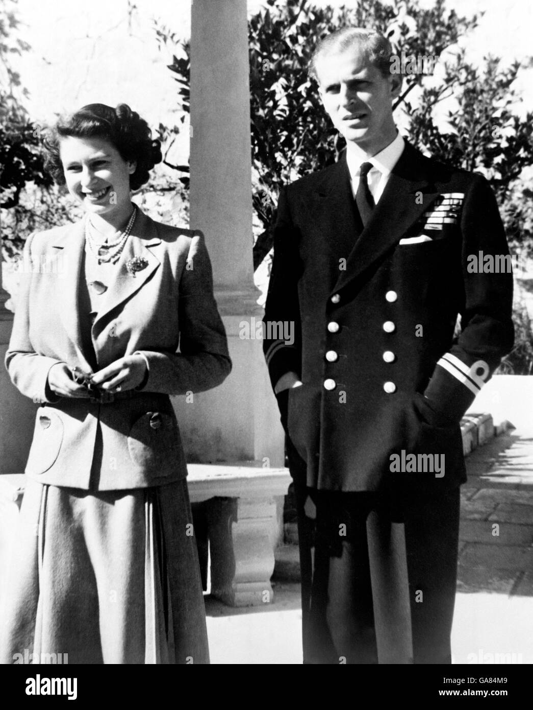 La princesse Elizabeth se fait un plaisir de sourire comme, avec le duc d'Édimbourg, elle profite du soleil de Malte dans le jardin de la Villa Guardamangia. Le duc d'Edinbugh servait à Malte en tant que premier lieutenant à bord du Destroyer de classe C et chef de la flottille, le HMS Checkers. Banque D'Images