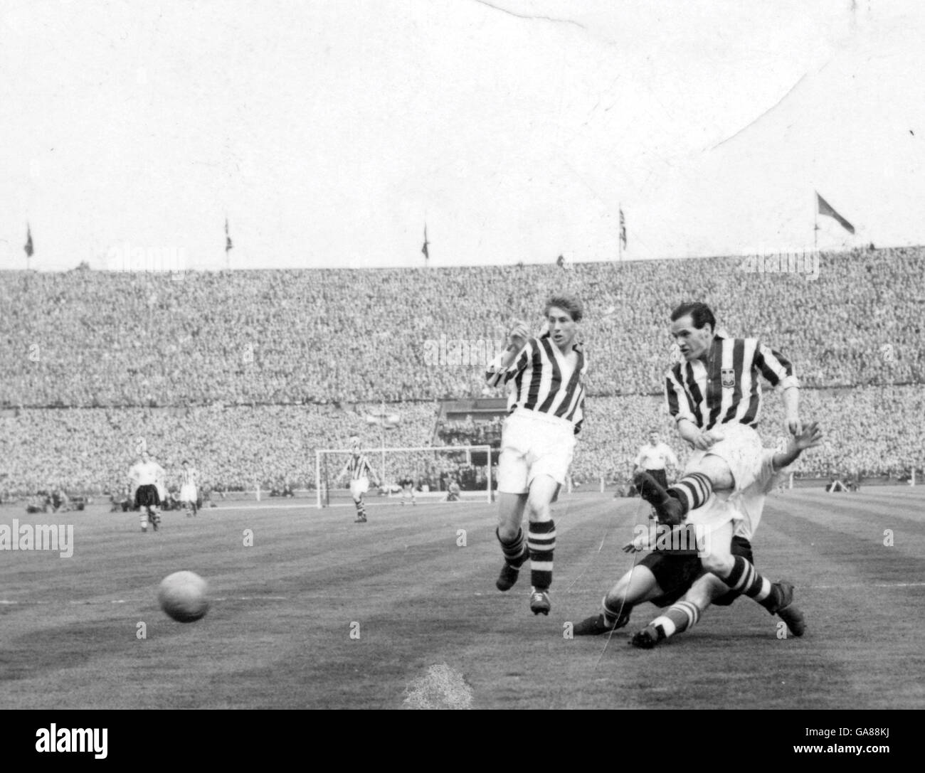 Willie Cunningham de Preston North End ne peut pas empêcher George Lee de West Bromwich Albion de mettre en place le coéquipier Frank Griffin (non représenté) pour marquer. Johnny Nicholls de West Bromwich Albion est photographié (l). Banque D'Images