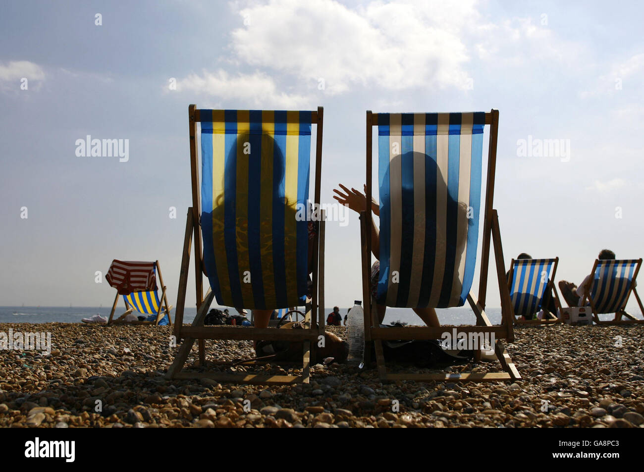 Les voyageurs d'une journée apprécient le temps des vacances d'août sur la plage de Brighton, Sussex. Banque D'Images
