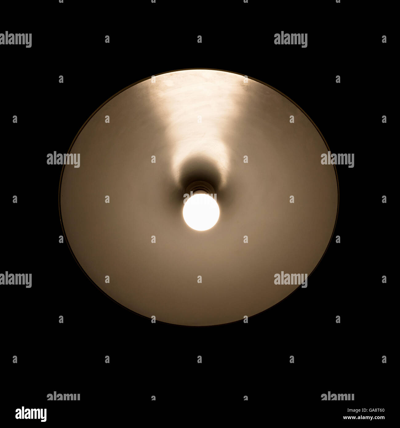 Lampe tungstène brillants dans l'abat-jour métallique ronde isoler sur fond noir Banque D'Images