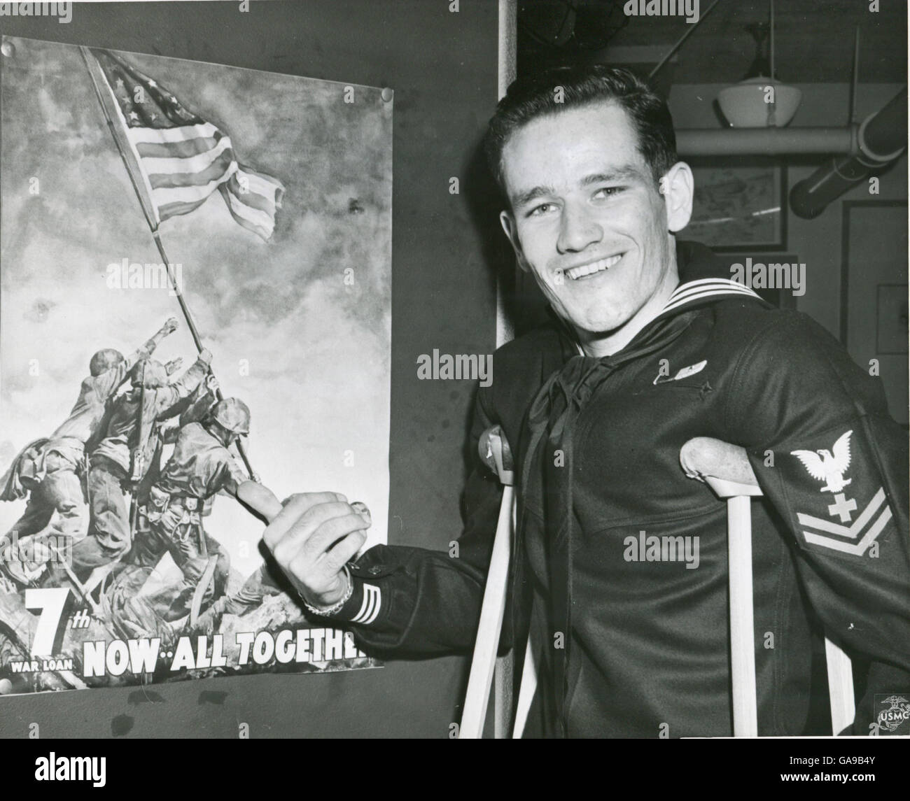 Pharmacien de la marine 4400 deuxième classe John H. Bradley points à la 7e guerre mondiale affiche Prêt qui porte l'image de l'historique du drapeau sur le mont Suribachi, Iwo Jima. Bradley a participé à l'événement tout en restant fixé à une unité de Marines dans la bataille. Banque D'Images