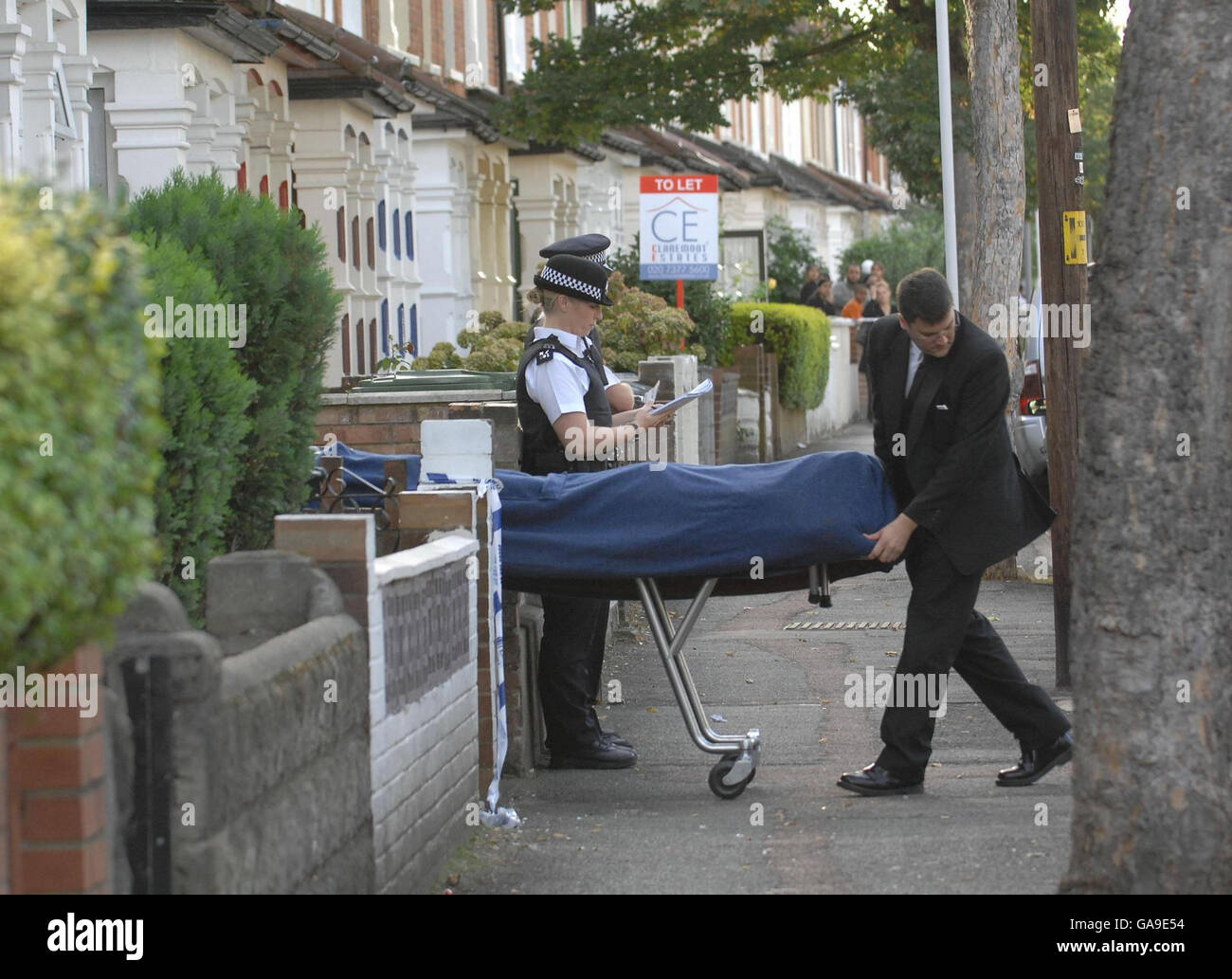 Garçon poignardé à mort dans la rue.Le corps d'un garçon de 17 ans est enlevé d'une maison dans l'est de Londres après un coup de poignarder la nuit dernière. Banque D'Images