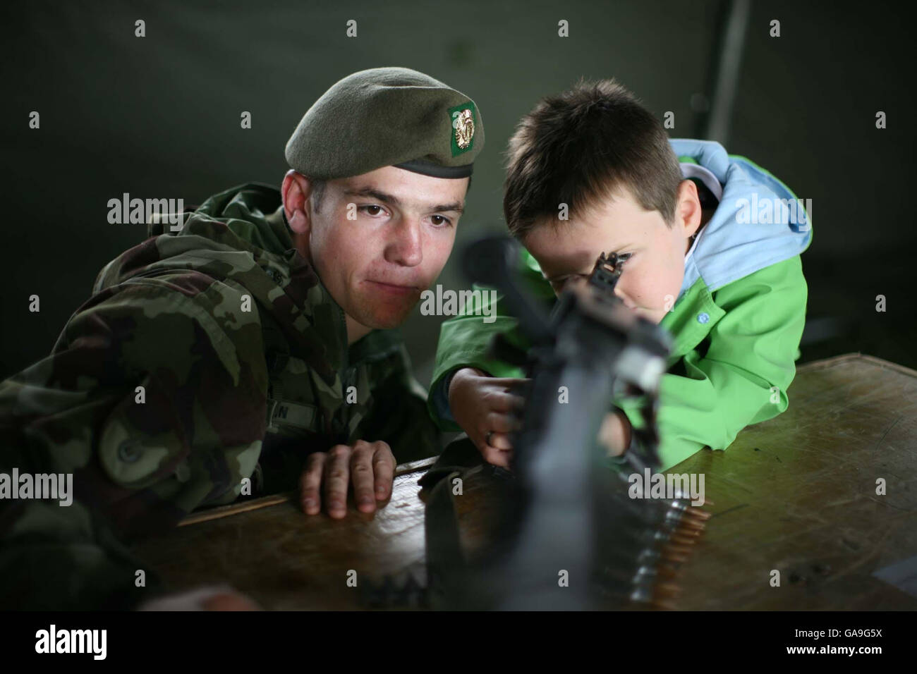 Reece Thompson, 4 ans, de Rathmolyon County Meath, à la recherche d'une mitrailleuse à usage général avec l'aide de CPL Daithi Mac Eamoinn, de la 62e bataille de la Réserve d'Infintary, Cathal Brugha Street à une tente de recrutement des forces de défense de l'armée irlandaise au Bray Air Display qui a eu lieu à Bray Seafront, comté de Wicklow en Irlande. Banque D'Images