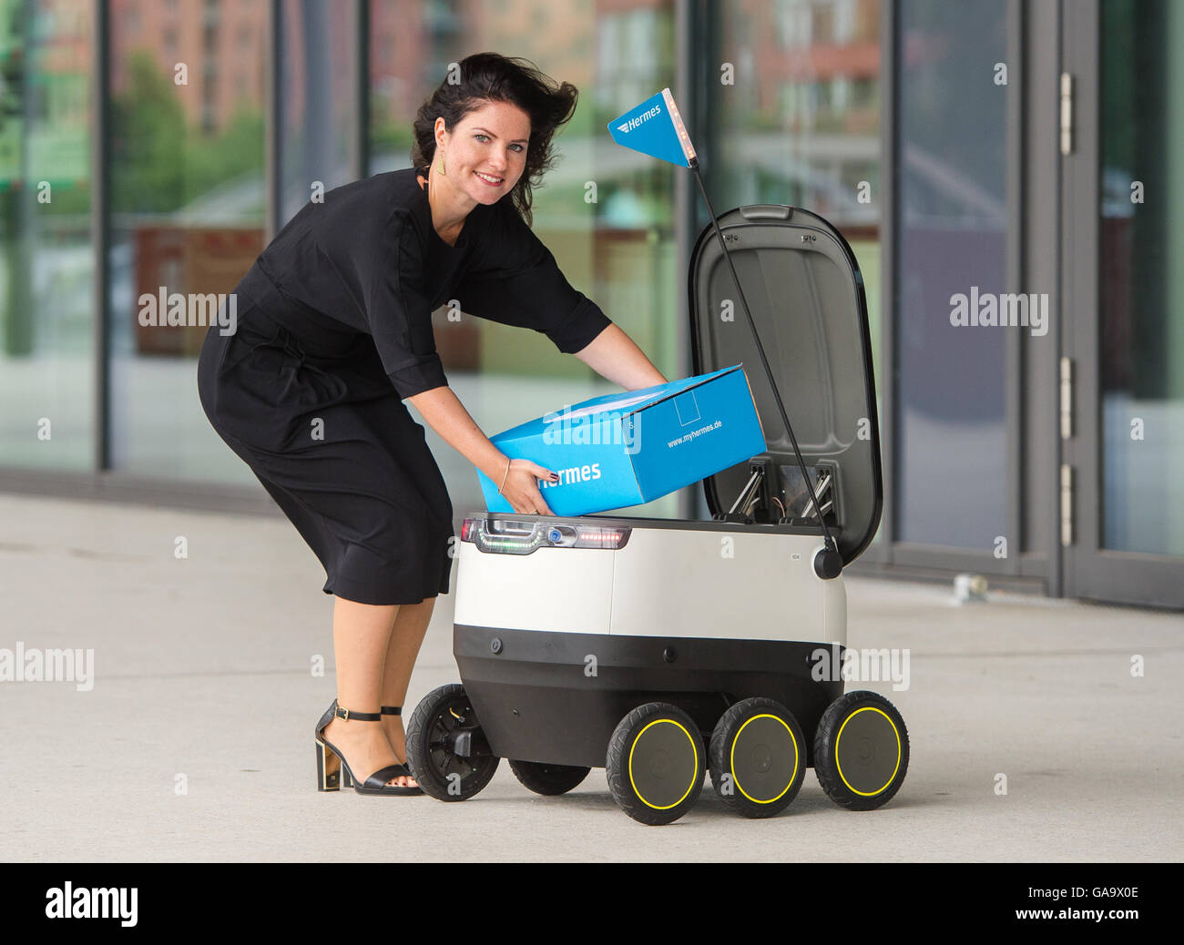 Daniela Kirchner à partir de la livraison de colis Hermes charge un robot développé par la société Technologies Starship pour Hermes à Hambourg, Allemagne, 04 août 2016. En août Hermes a commencé un test-run de la livraison du robot à Hambourg. Photo : DANIEL BOCKWOLDT/dpa Banque D'Images