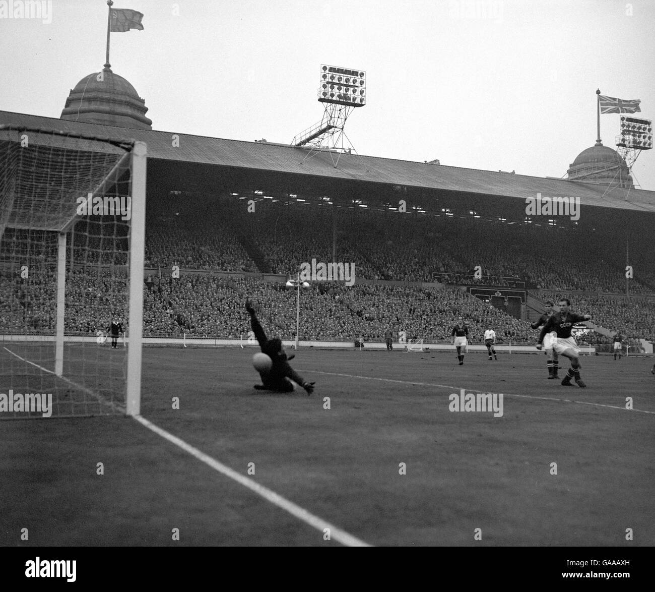 Le gardien de but russe Vladimir Belyayev est battu par une balle de Johnny Haynes (non illustré) en Angleterre pour saisir le deuxième but de son équipe. Banque D'Images