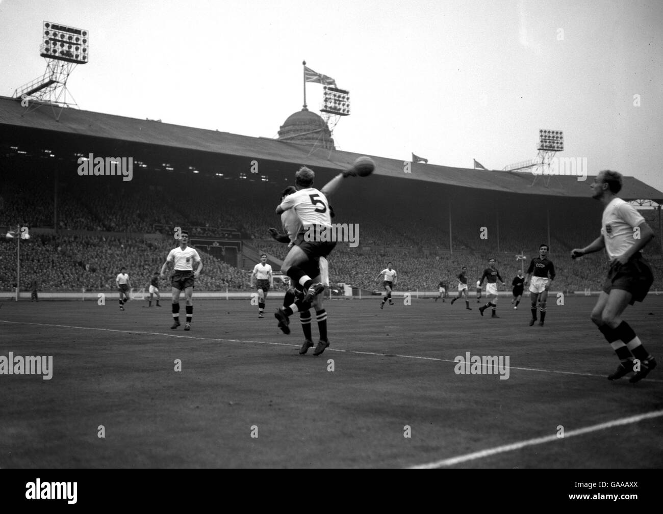 Le gardien de but de l'Angleterre Colin McDonald, qui est pris en sandwich entre le coéquipier Billy Wright et le russe Nikita Simonyan, réussit à chasser le ballon. Banque D'Images