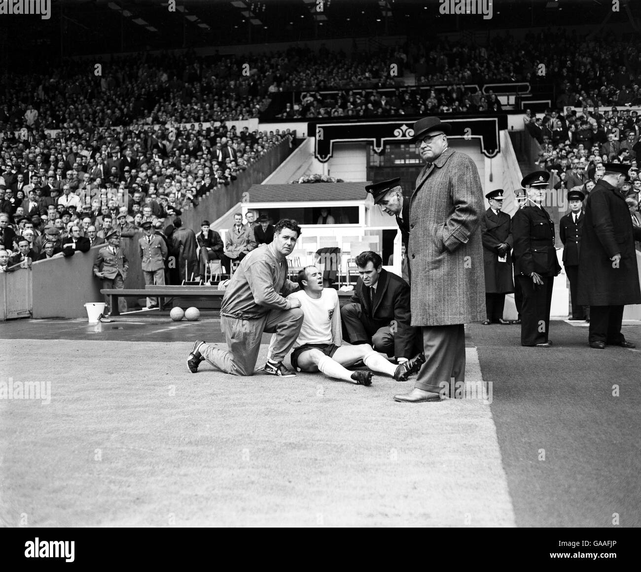 Football - Championnat international de football - Angleterre / Ecosse.Ray Wilson (c) d'Angleterre reçoit l'attention du formateur Harold Shepherdson (l) et de son coéquipier John Connelly (r) après avoir pris une blessure Banque D'Images