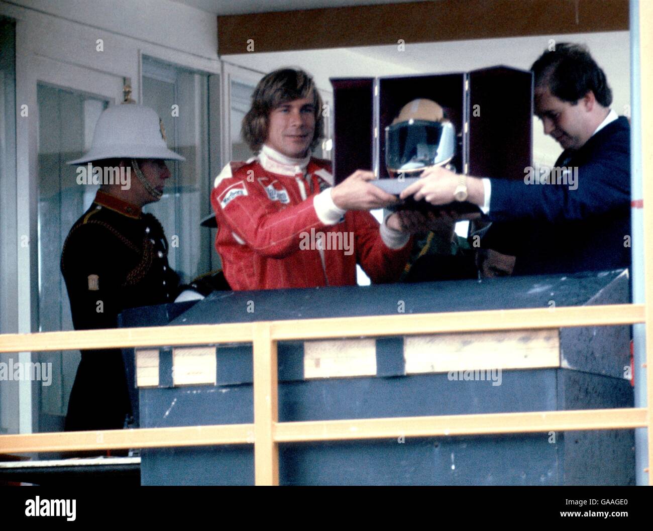 (G-D) le champion du monde de Formule 1, James Hunt, reçoit un casque d'or de Lord Hesketh Banque D'Images
