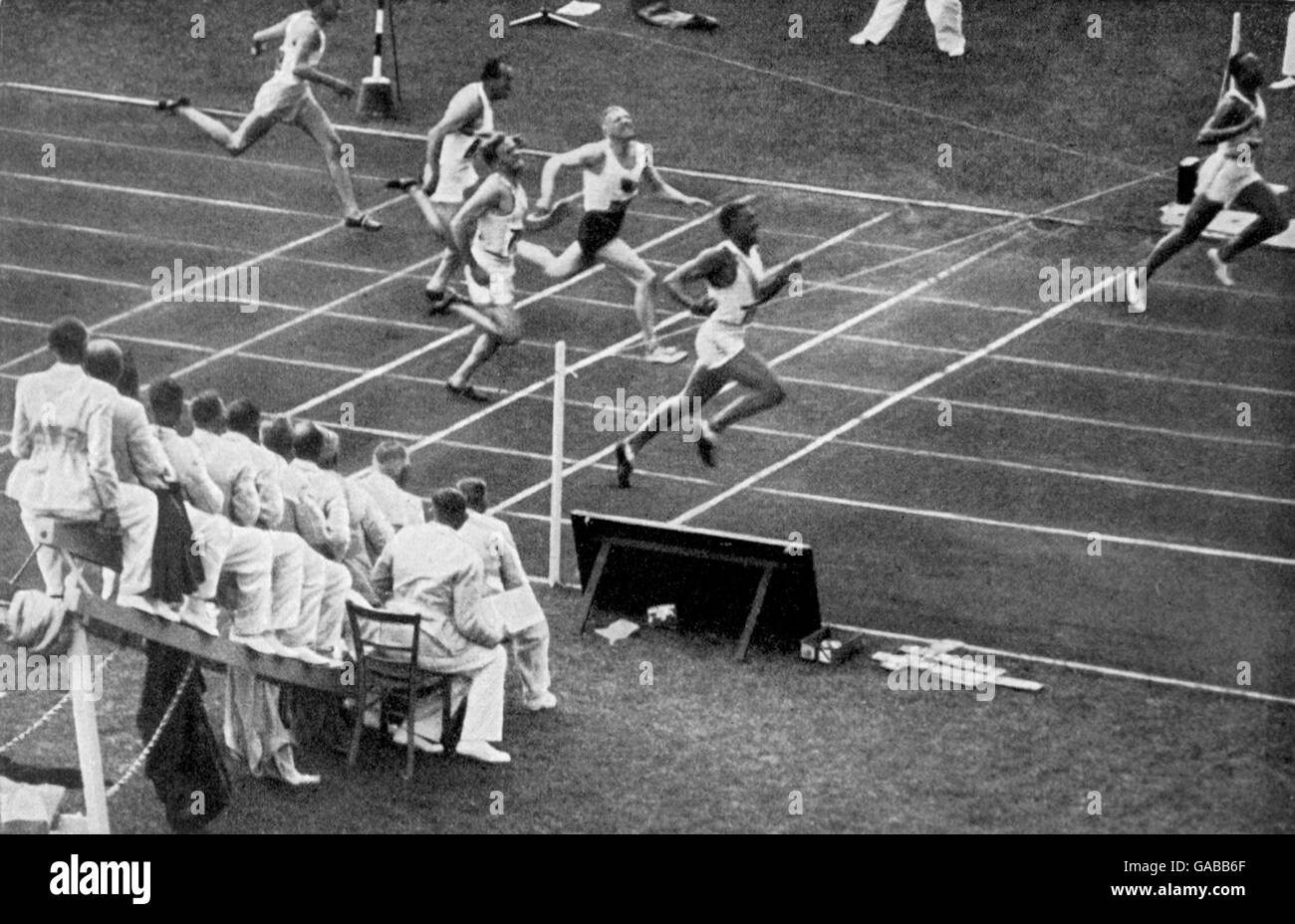 (R-L) Jesse Owens des États-Unis brise la bande pour gagner l'or alors que son coéquipier Ralph Metcalfe rentre à la maison pour gagner l'argent, et Martinus Osendarp des pays-Bas pour obtenir le bronze Banque D'Images