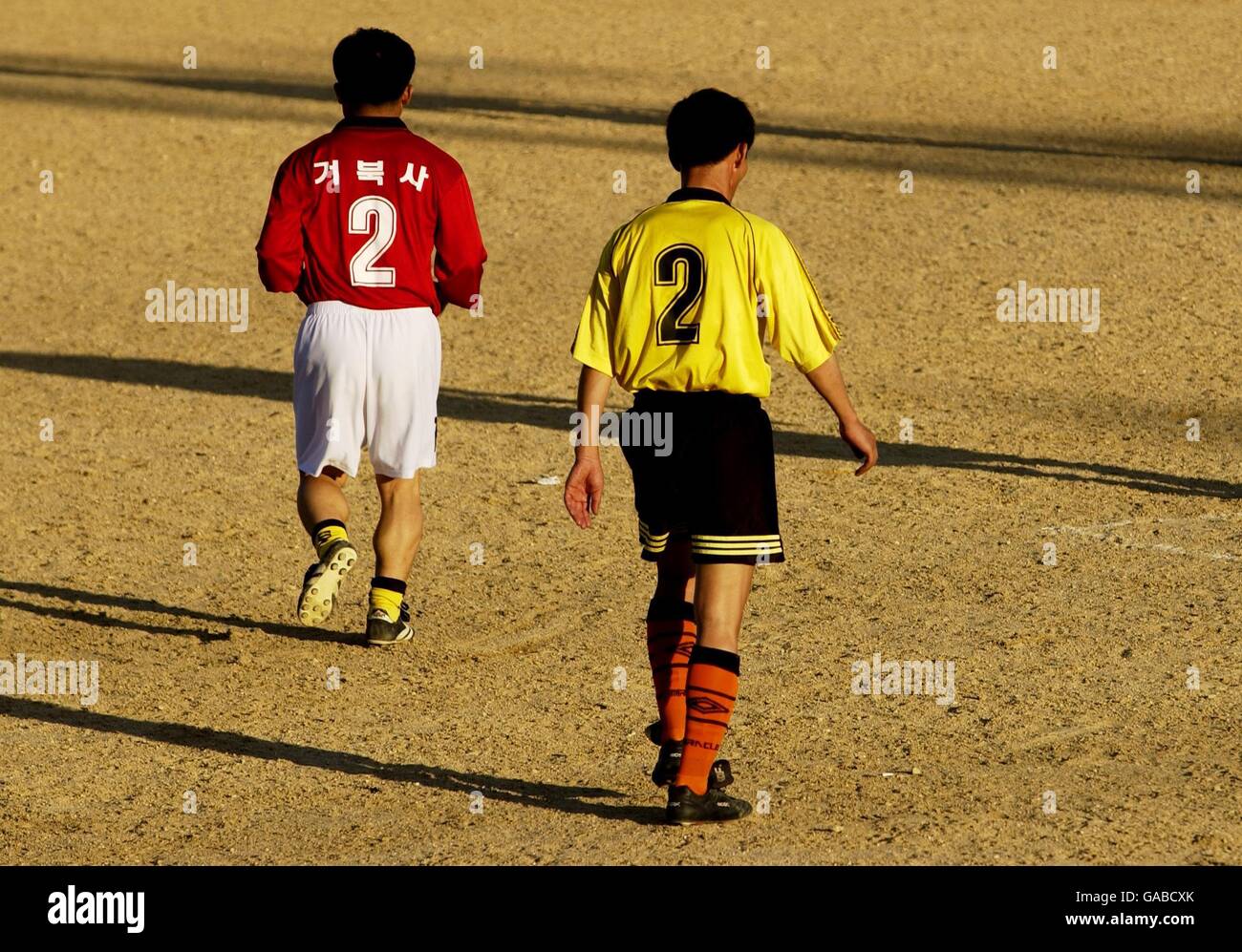 Football - coupe du monde de la FIFA 2002 - football en Corée.Au cours d'une séance de motch impliquant des chauffeurs de taxi, deux joueurs entrent sur un terrain de football de sable sur l'île de Jeju en Corée du Sud Banque D'Images
