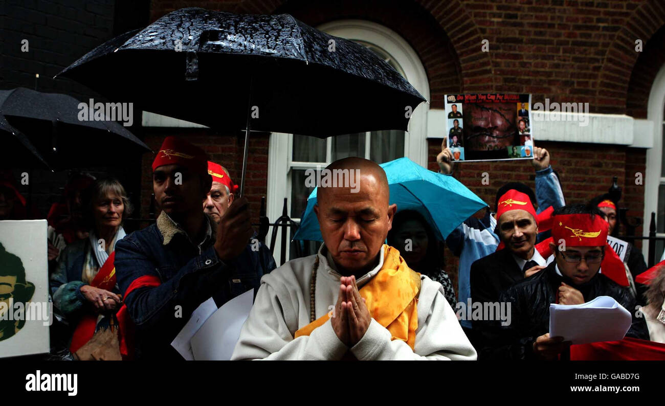 Les moines bouddhistes prient sous une forte pluie à l'extérieur de l'ambassade de l'Union du Myanmar à Mayfair, Londres, pour manifester leur soutien aux manifestations des Monks bouddhistes en Birmanie. Banque D'Images