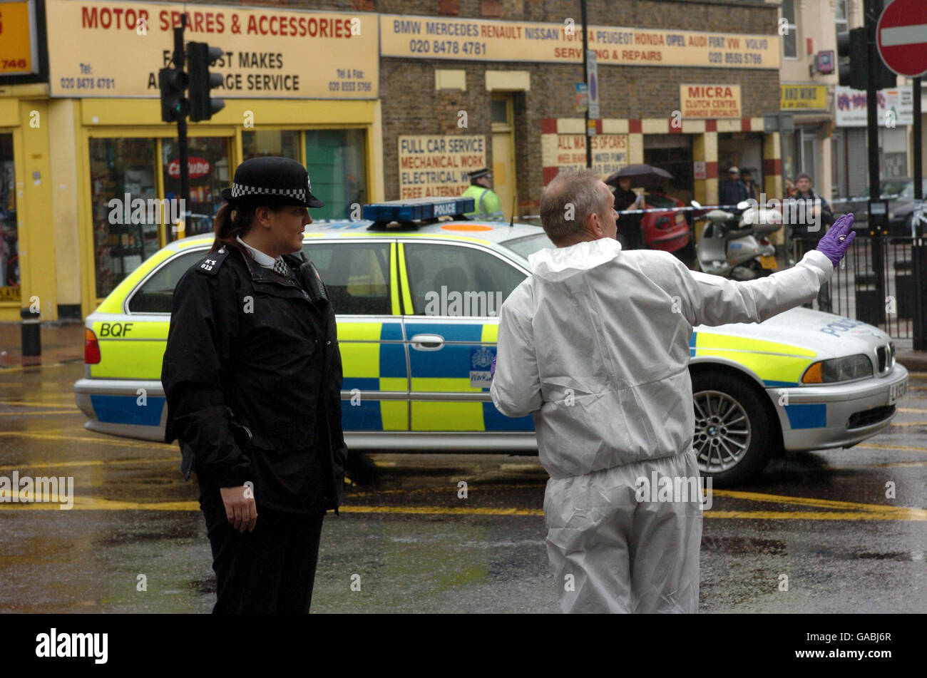 Des policiers sur les lieux à Ilford, dans l'est de Londres, où un jeune homme a été tué lorsqu'il est tombé sous un bus et est tombé piégé sous les roues. Banque D'Images