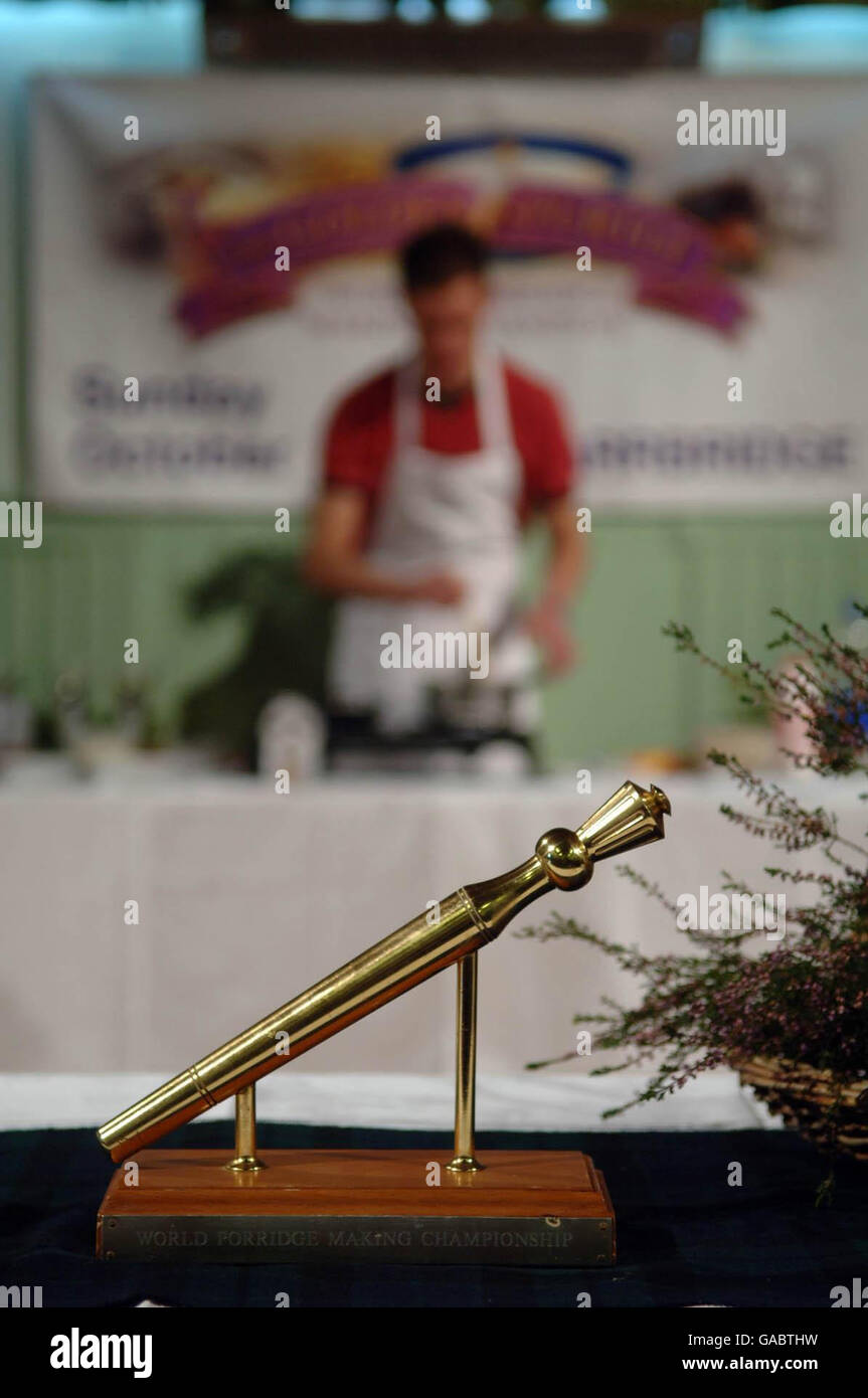 Le « Golden Spurtle », vu lors du 14e championnat du monde de fabrication de bouillies annuel à Carrbridge, en Écosse, tandis qu'un fabricant de bouillie prépare son bouillie en arrière-plan. Banque D'Images