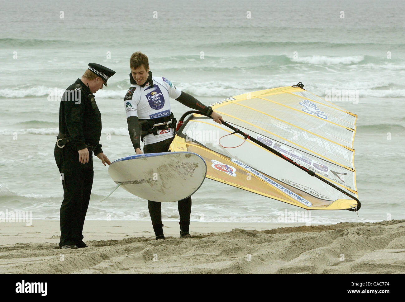 Danny Lapsley, policier local de la police de Strathclyde, s'entretient avec Tuomo Naalisvaara, le windsurfeur finlandais, alors qu'il était sur la plage de Balevullin sur l'île de Tiree. Banque D'Images