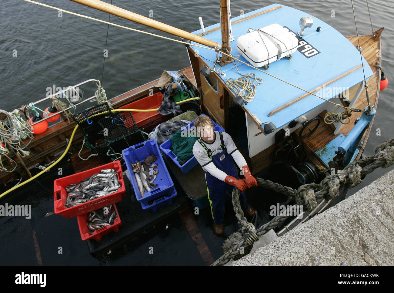 Pêcheur de homard Ross MacLennon Skipper du bateau « Carrie Anne » De Milton Harbour sur l'île de Tiree avec matelet William Walker (portant un chapeau) débarque du homard dans l'océan Atlantique Banque D'Images