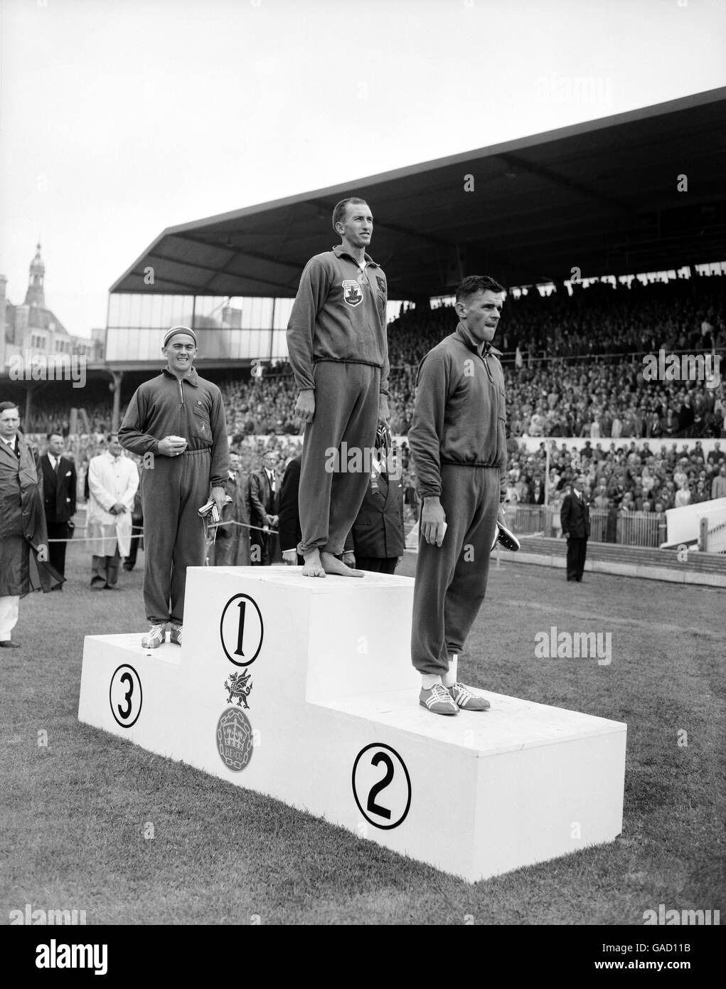 (G-D) trois Australiens se tiennent sur le podium pour recevoir leurs médailles pour le Mile masculin : le médaillé de bronze Albert Thomas, le médaillé d'or Herb Elliot, le médaillé d'argent Merv Lincoln Banque D'Images