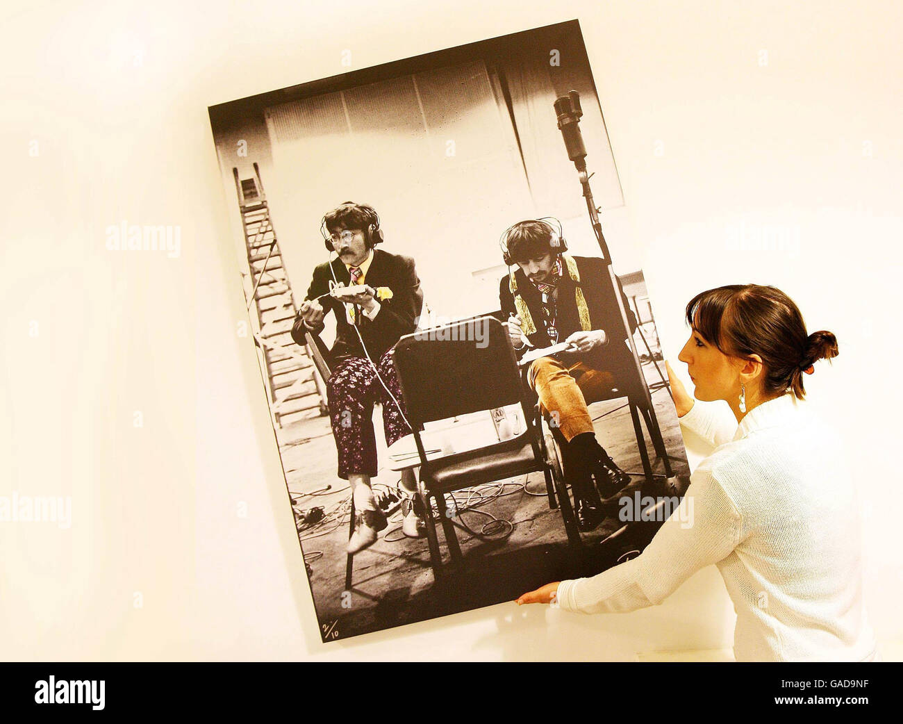 Un employé de la Leinster Gallery, à Dublin, porte une photo de John Lennon  et Ringo Starr, de l'exposition « Unseen Beatles », avec des photos des  Beatles par le célèbre photojournaliste