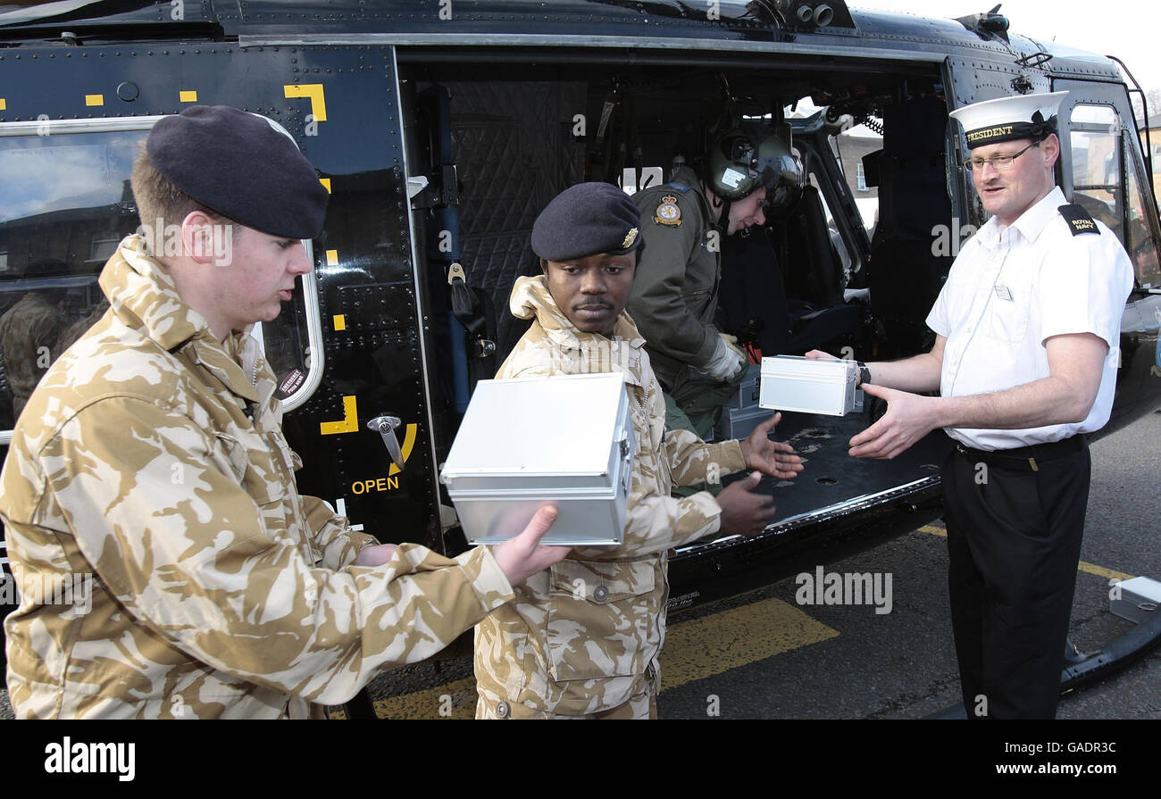 Les membres du 9 Supply Regiment, Royal Logistics Corp aident à charger un hélicoptère avec des boîtes de noël de « bas carré » pour distribution parmi le personnel de service dans le monde entier à la caserne de Regents Park, Albany Street à Londres. Banque D'Images