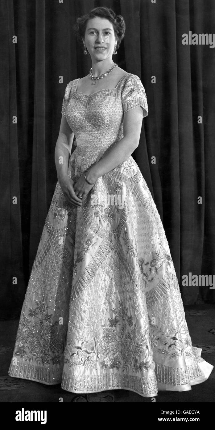 Portrait de sa Majesté la reine Elizabeth II dans le trône Chambre Buckingham Palace portant sa magnifique robe de couronnement conçue par Norman Hartnell 1953 satin blanc cousu avec des milliers de perles et broderie en cristal Banque D'Images