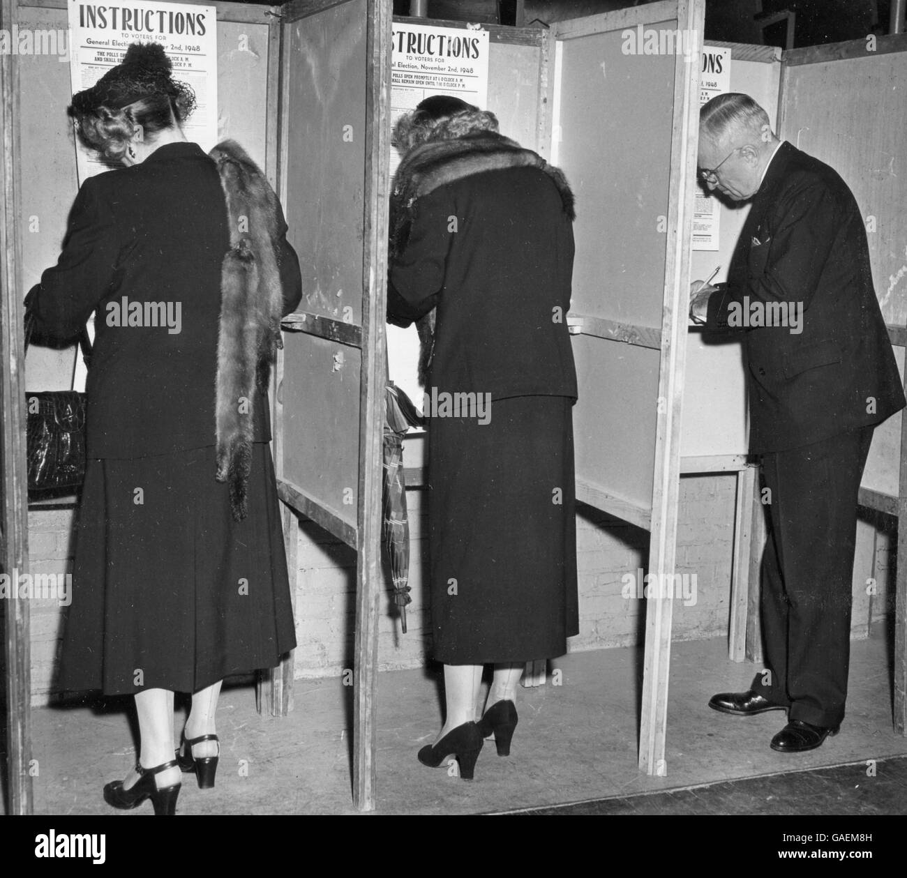 Sur la photo à marquer son bulletin de vote, des isoloirs, de gauche à droite, Mme Harry S. Truman (Bess), sa fille Margaret Truman et le Président Harry S. Truman. Banque D'Images
