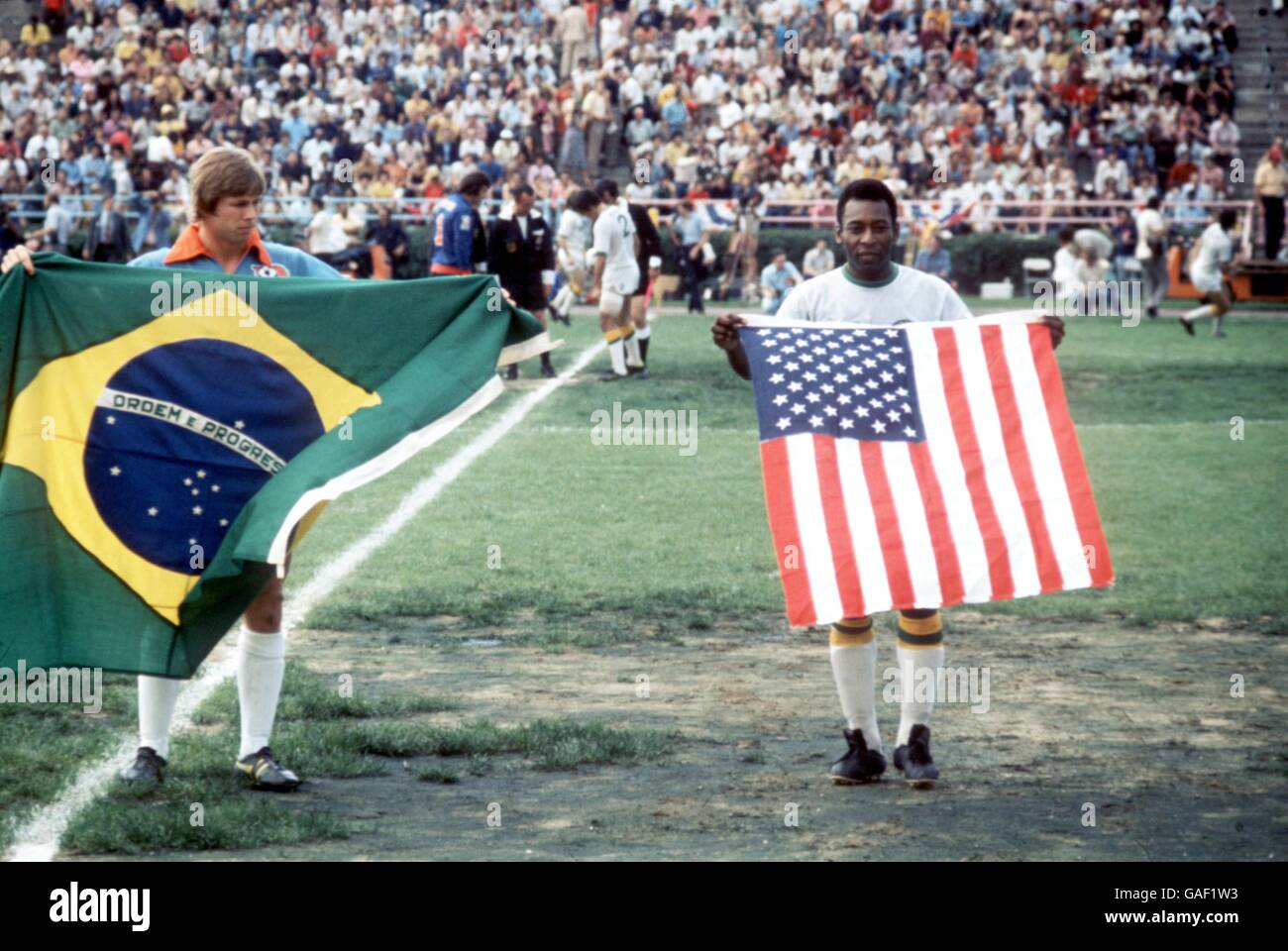 Le Pele (r) de New York Cosmos tient les étoiles et les Stripes comme joueur de Dallas Tornado détient un drapeau brésilien (beaucoup plus grand), quelques minutes avant le lancement du premier match de Pele pour le Cosmos Banque D'Images