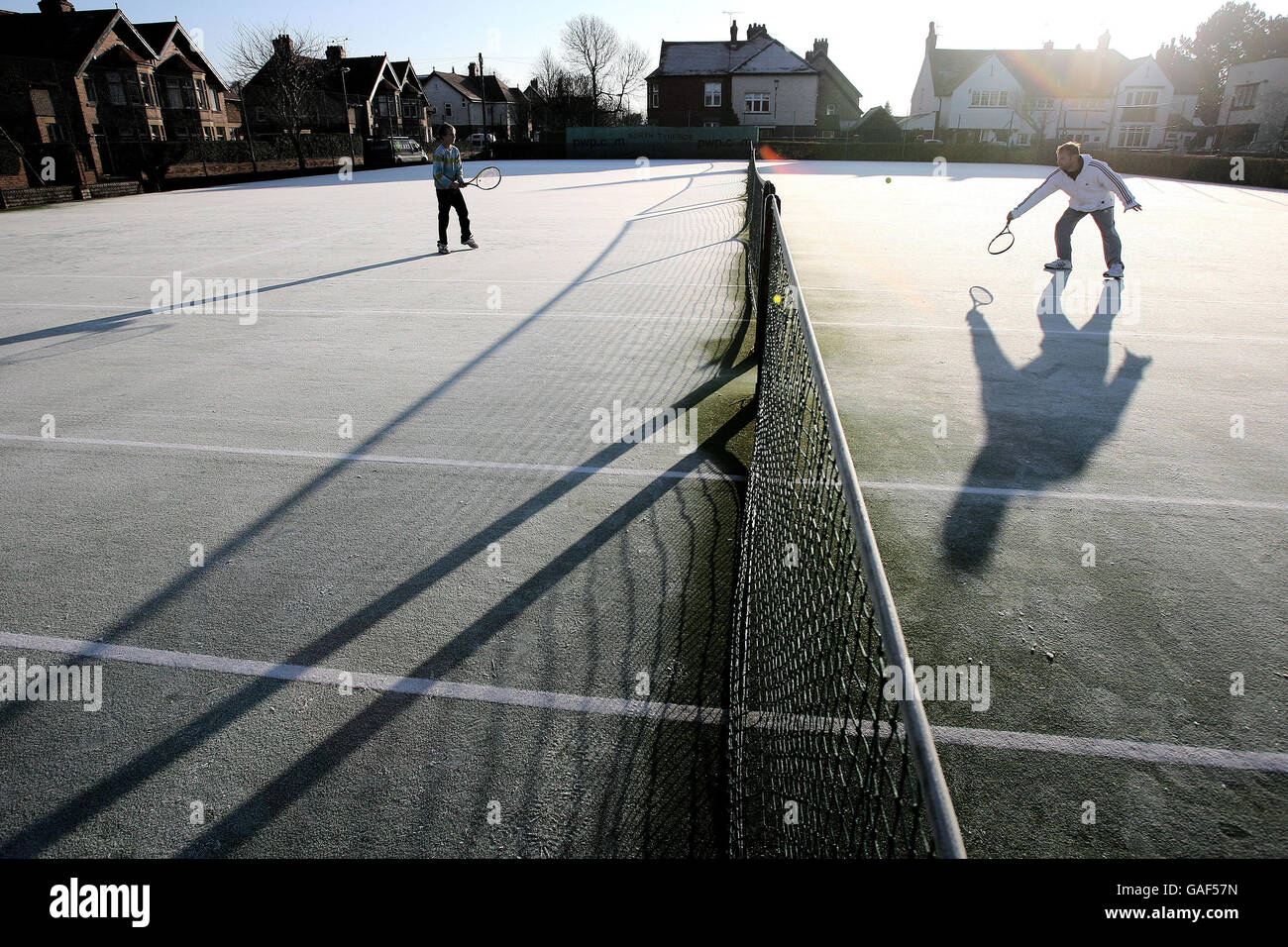 Un couple pratique du tennis sur un terrain recouvert de gel à Monkseaton, près de Whitley Bay, après que les températures de nuit sont tombées sous le gel dans certaines parties du pays. Banque D'Images