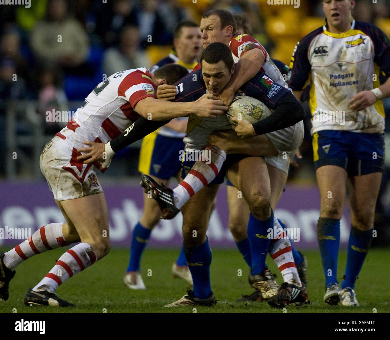 Vinnie Anderson de Warrington est affronté par Pat Richards de Wigan et Mick Higham lors du match amical au stade Halliwell Jones, à Warrington. Banque D'Images
