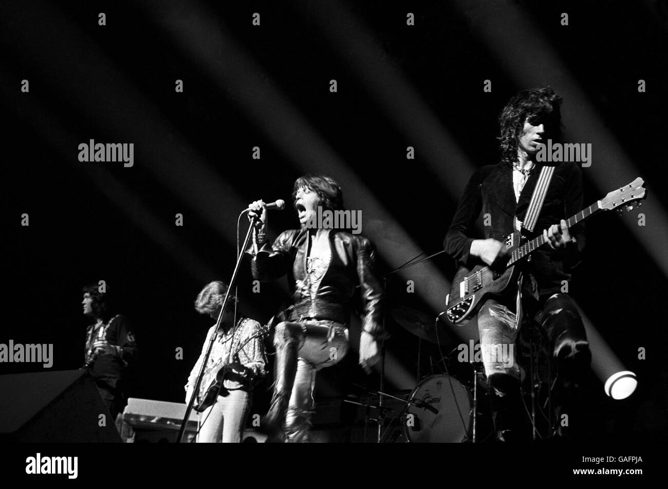 Mick Jagger des Rolling Stones sur scène au stade Wembley dans une veste de motocyclisme sur un costume en cuir satiné doré Banque D'Images