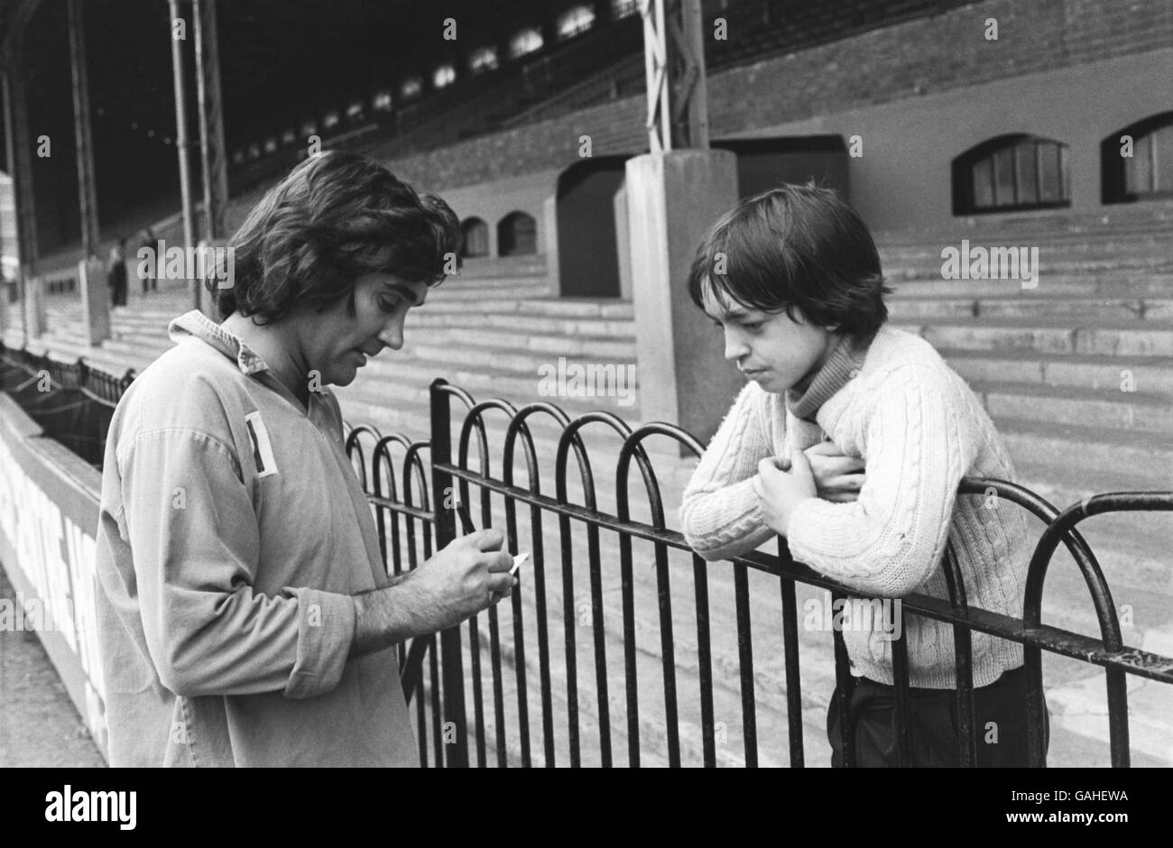 George Best de Fulham signe un autographe pour un jeune fan à son retour à Craven Cottage, quelques semaines seulement après avoir tourné le dos à Fulham pour rejoindre son club en Amérique, les Aztèques de Los Angeles, affirmant que Fulham lui devait de l'argent sur son contrat Banque D'Images