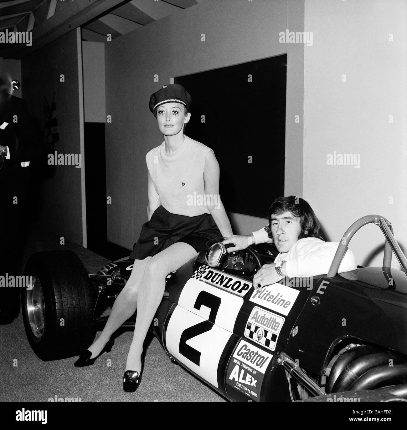 Jackie Stewart est accompagné d'un modèle pour annoncer Dunlop pneus Banque D'Images