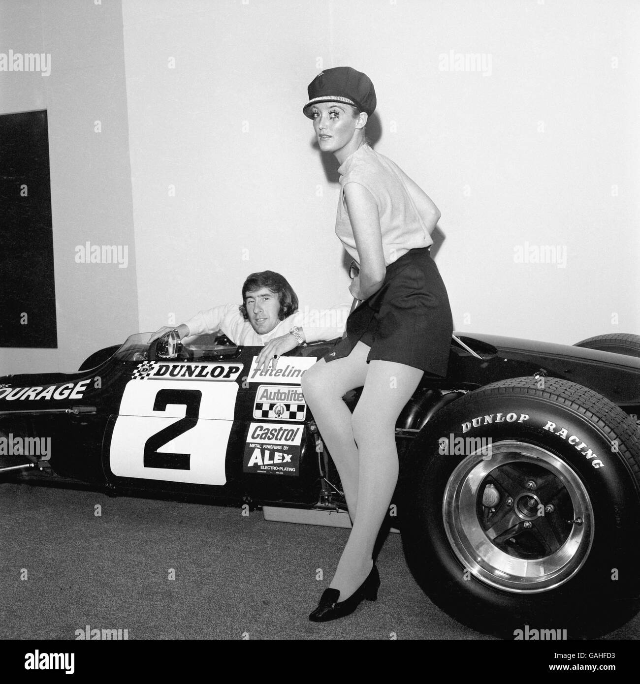 Jackie Stewart est accompagné d'un modèle pour annoncer Dunlop pneus Banque D'Images