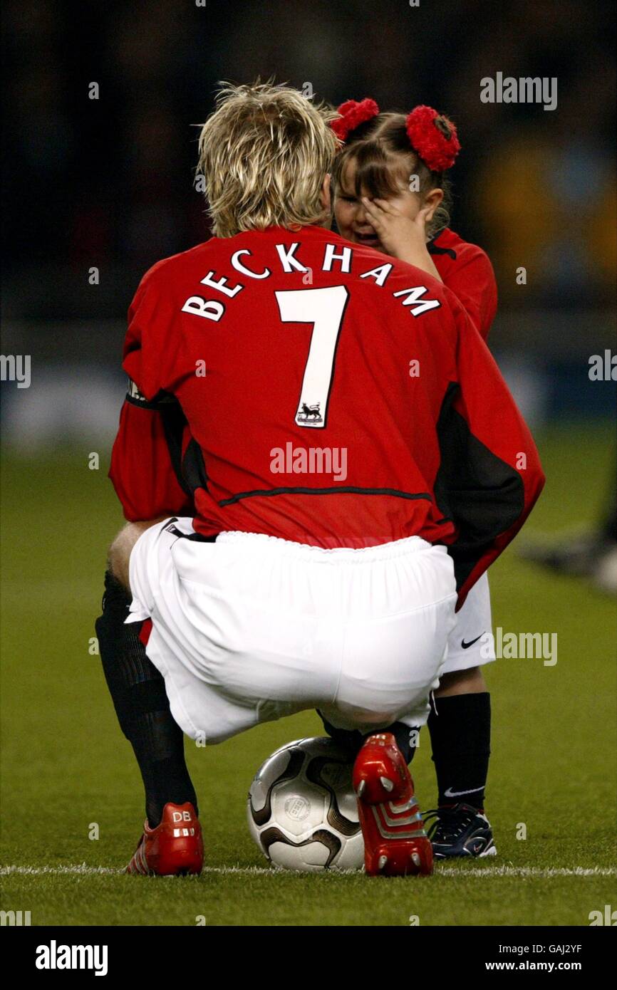 David Beckham, la cacaptine de Manchester United, réconforte la jeune mascotte après elle est trop venue avec les nerfs Banque D'Images