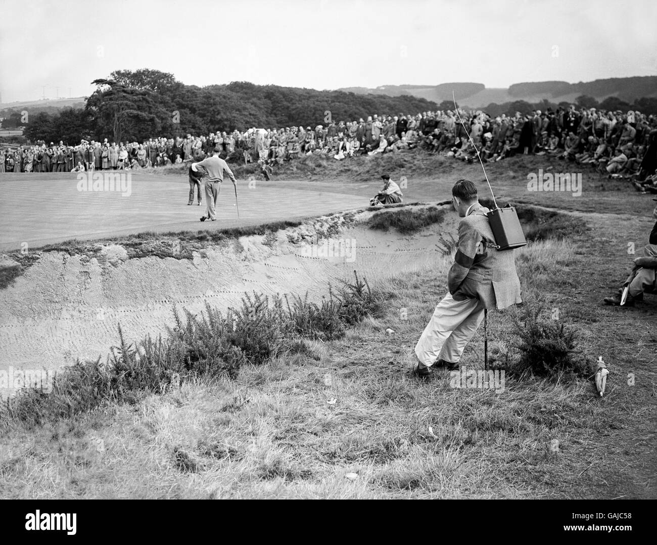 Les postes de radio talkie-walkie ont été utilisés pour renvoyer les derniers scores de chaque match au tableau d'affichage.En arrière-plan Sam Snead des États-Unis putts, regardé par Charlie Ward. Banque D'Images