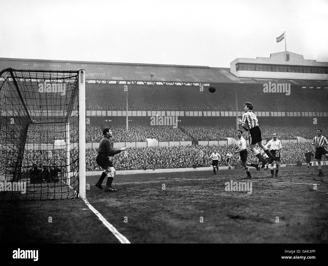 Football - League Division One - Tottenham Hotspur v Sheffield Wednesday - White Hart Lane.Derek Dooley (à droite) qui traverse la défense des Spurs et envoie un entête vers le gardien de but des Spurs Ted Ditchburn. Banque D'Images