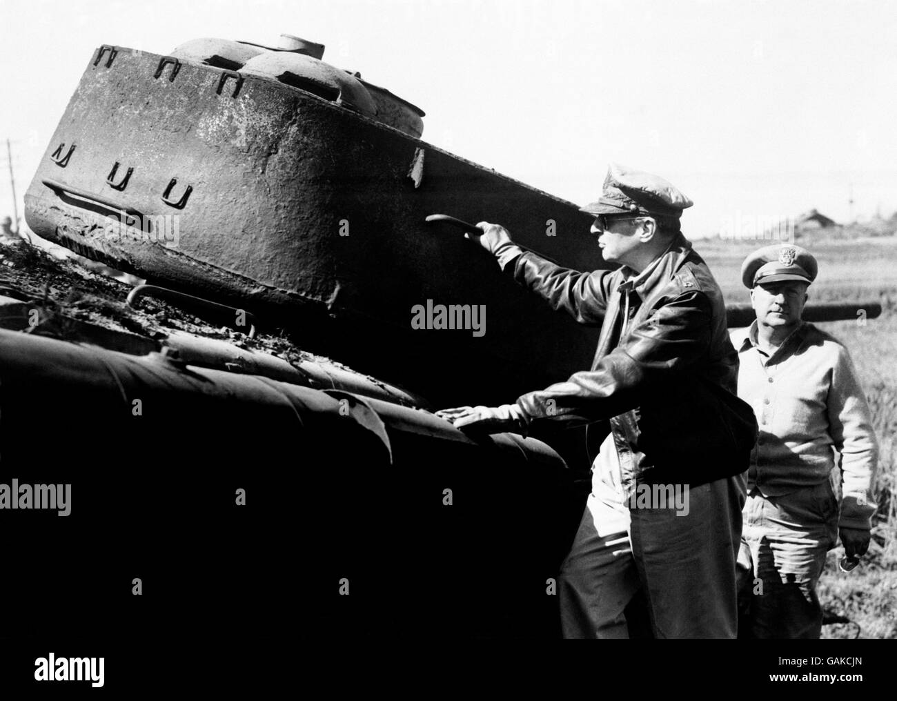 Le général de l'armée Douglas MacArthur, commandant en chef des forces des Nations Unies en corée, examine un char nord-coréen battu laissé derrière lui par un ennemi en retraite quelque part près du front coréen. Banque D'Images