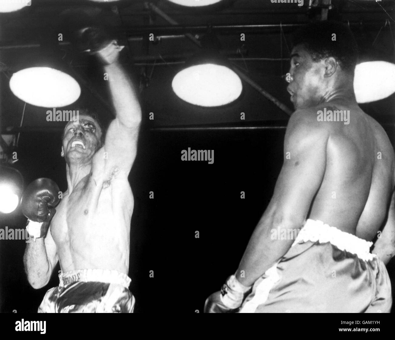 Boxe - combat lourd - Cassius Clay contre Henry Cooper.Cassius Clay (r) se déporte alors qu'il se déporte d'un crochet gauche punissant lancé par Henry Cooper (l) Banque D'Images