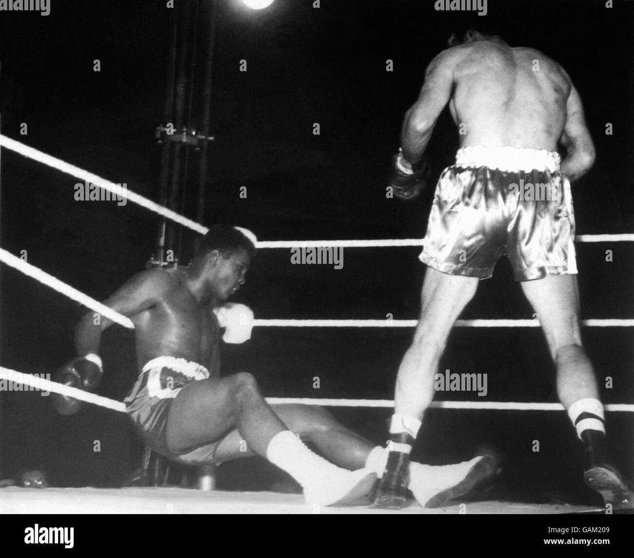 Henry Cooper (r) se dresse alors que Cassius Clay (l) s'effondre sur les cordes après que Cooper a lancé 'Ammer d'Enery vers la fin du quatrième tour Banque D'Images