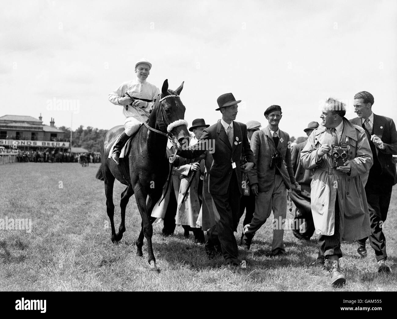 Le vainqueur de la course « Pearl Diver », George Bridgland UP, est conduit dans l'enceinte des gagnants par son propriétaire, le Baron Geoffrey de Waldner. Banque D'Images