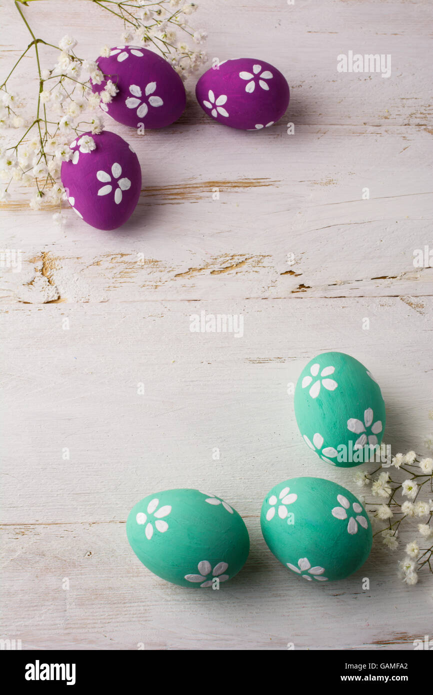 Turquoise et rose pâle oeufs de Pâques décorés sur un fond en bois blanc, vertical, de l'espace pour texte, copy space Banque D'Images