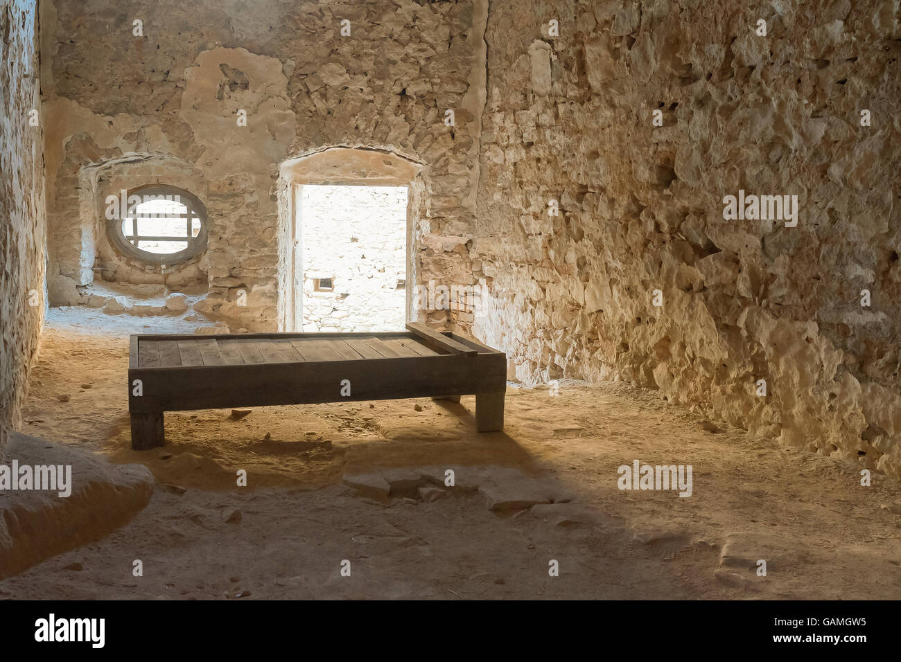 Ancienne cellule de prison au château de Palamidi en Grèce avec un lit en bois. Banque D'Images
