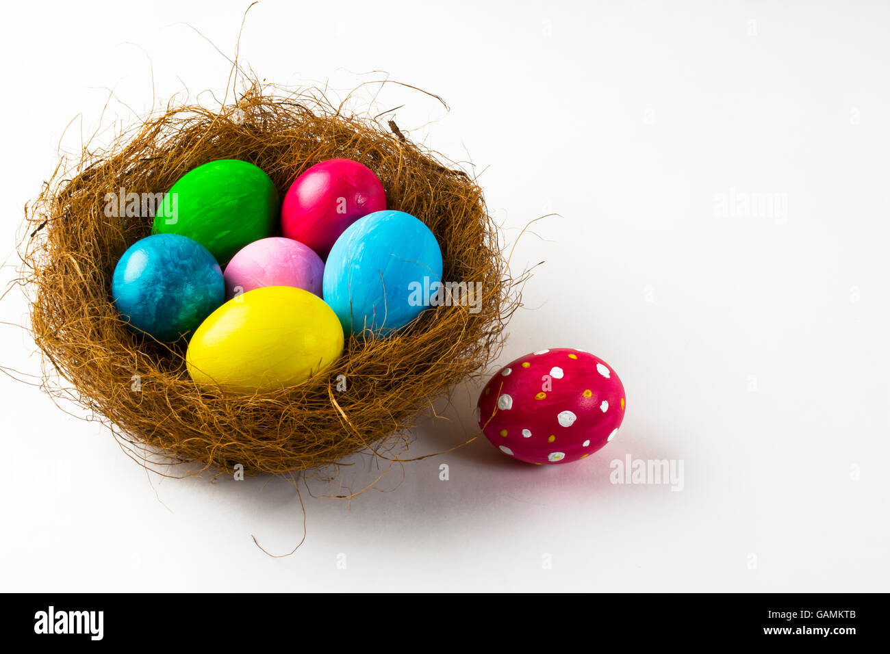 Les oeufs de Pâques multicolores dans un nid et œufs de Pâques rose avec abstract design sur fond blanc. Arrière-plan de Pâques. Easter symbo Banque D'Images