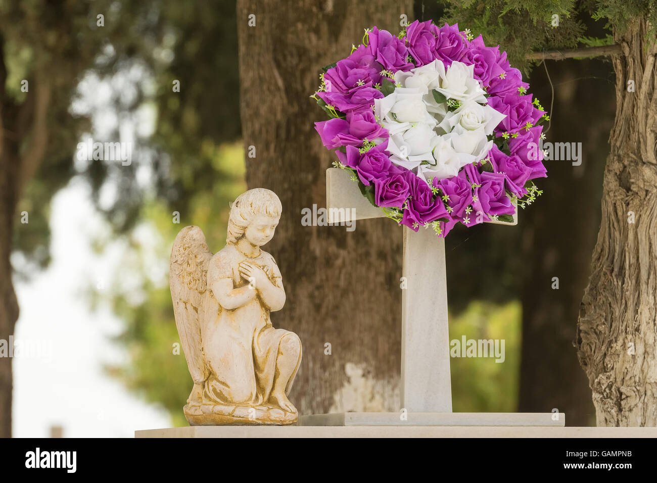 Guirlande de fleurs et une statue sur une tombe après un enterrement. Banque D'Images
