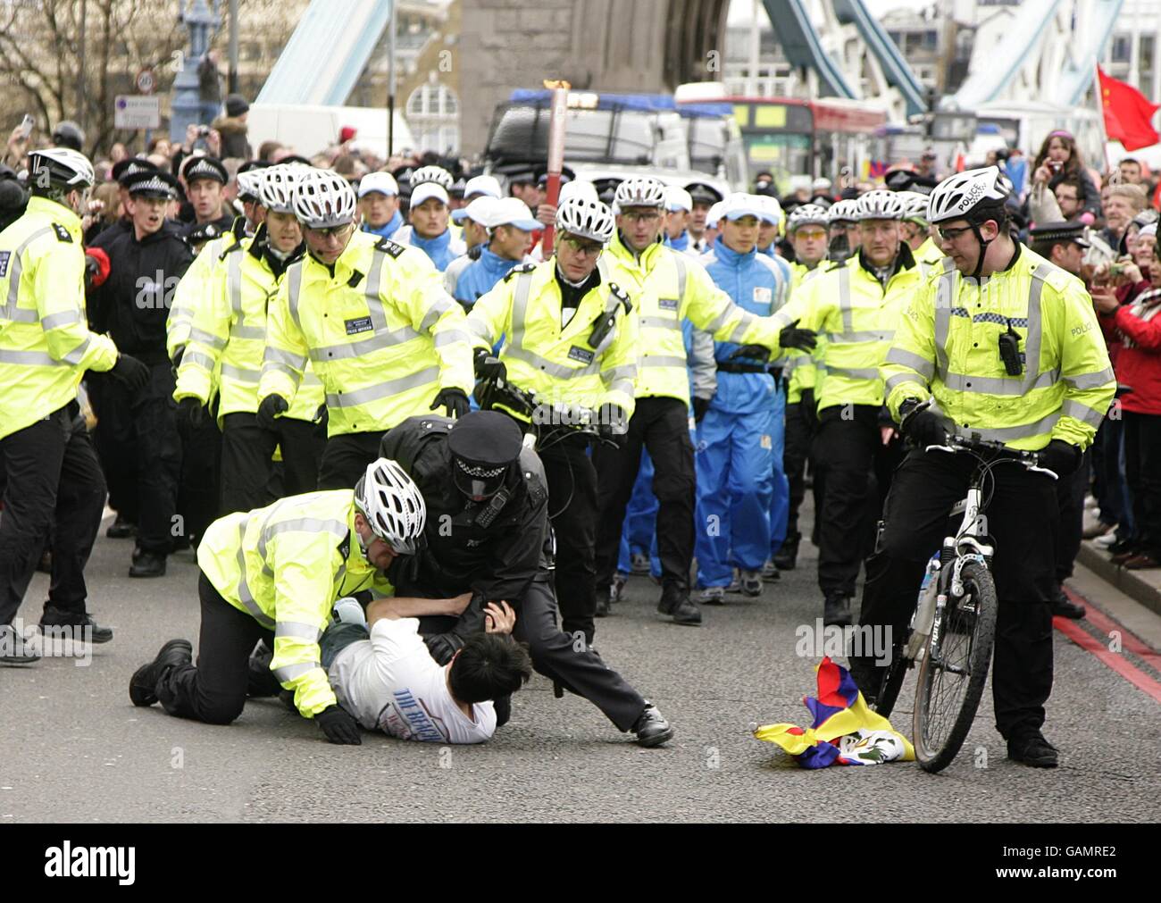 Un manifestant est à l'attaque par la police près de Tower Bridge pendant Le relais de la torche des Jeux Olympiques de Beijing à Londres Banque D'Images