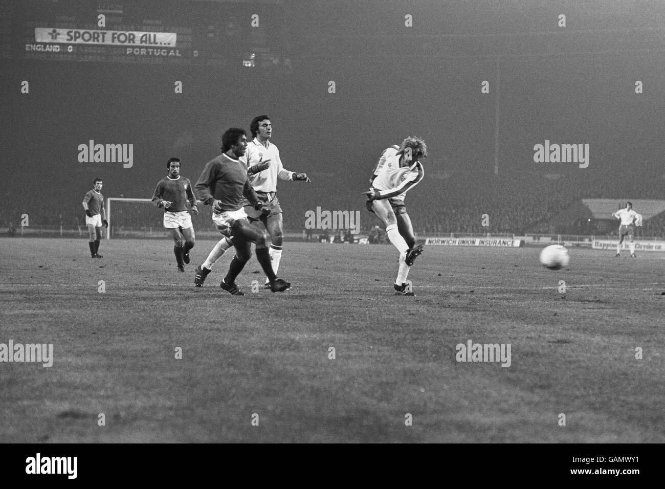 Football - qualifications de championnat d'Europe - Groupe un - Angleterre / Portugal.Colin Bell, d'Angleterre, tente un coup de feu à l'objectif portugais comme Osvaldinho du Portugal court à défier. Banque D'Images