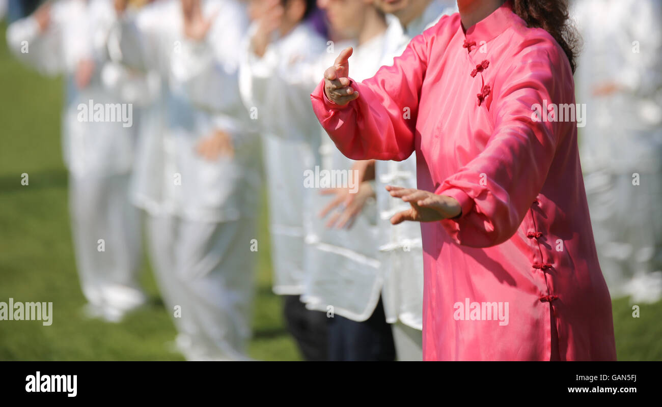 L'art martial Femme avec robe de soie rose parfaitement exécuter les exercices dans le parc public Banque D'Images